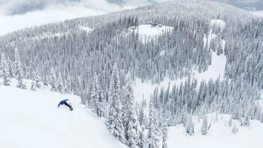 A view of a snowboarder going down a mountain in Revelstoke, North America