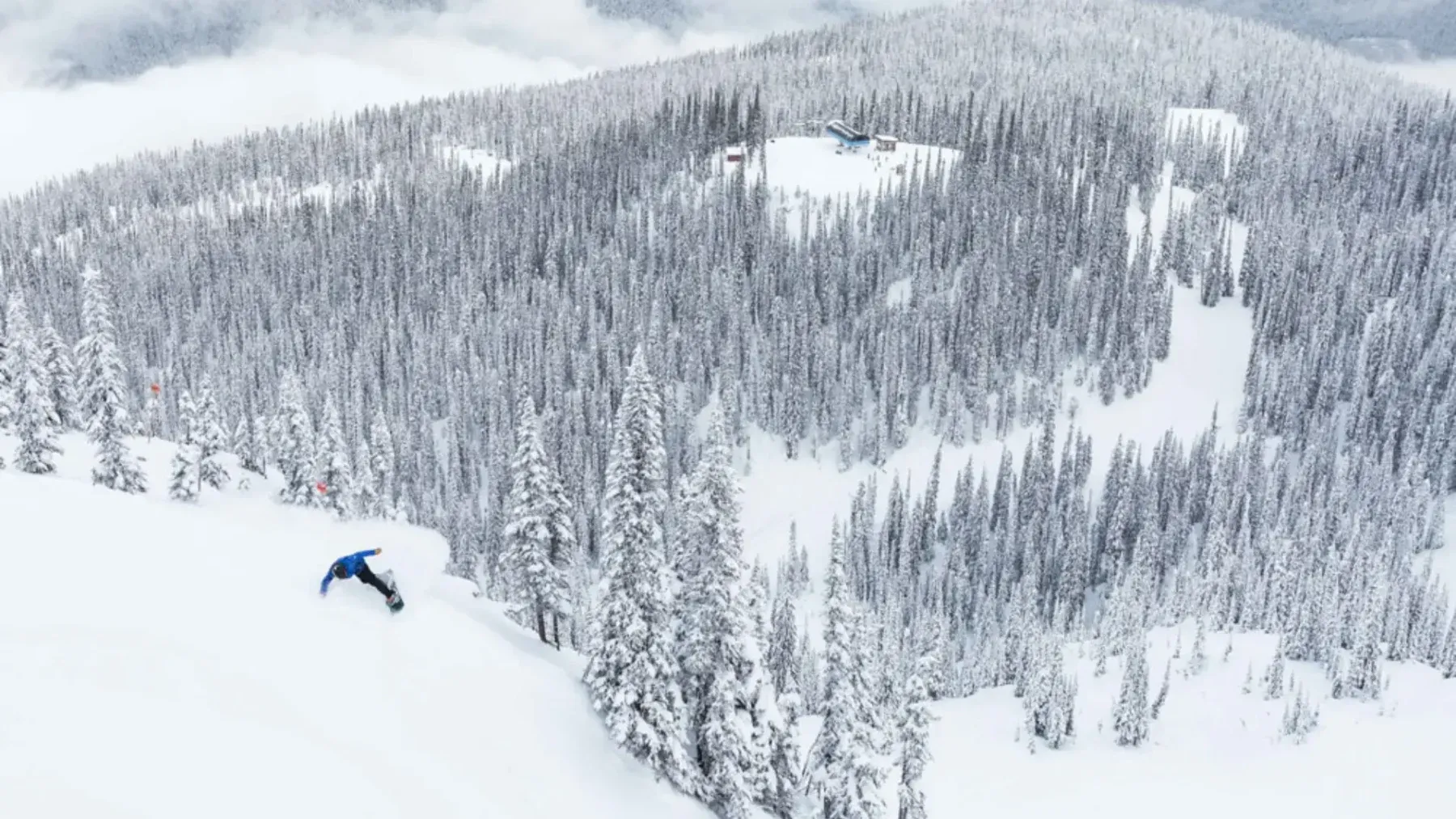A view of a snowboarder going down a mountain in Revelstoke, North America