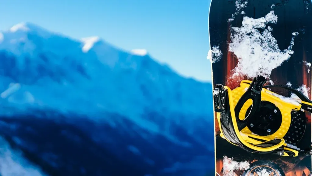 A snowboard standing upright in the snow on a mountain in the Alps